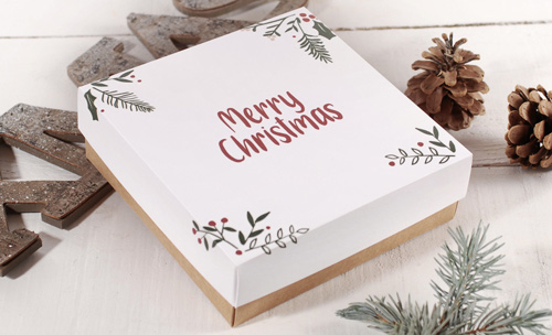 Caja blanca con mensaje Merry Christmas y decoración natural navideña