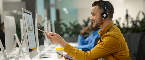 Profesional analizando gráficos en un ordenador mientras gestiona métricas relacionadas con un marketplace vertical