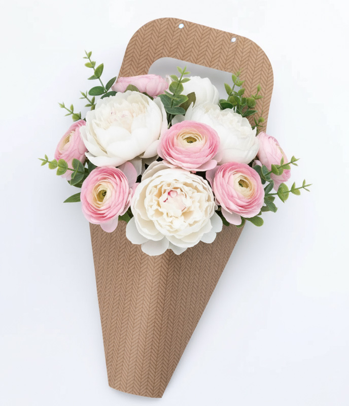 Ramo de peonías blancas y ranúnculos rosados en packaging de cartón kraft con asa integrada