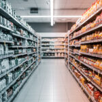 Pasillo de supermercado con estanterías ordenadas según planograma de productos para mejorar la exhibición