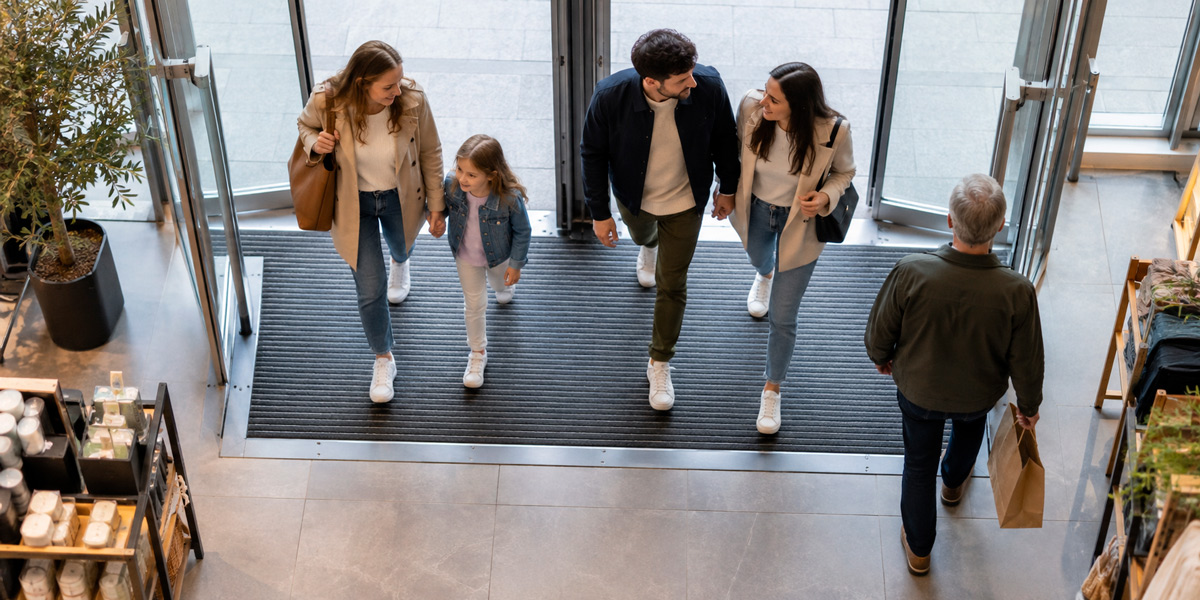 Grupos de clientes entrando y saliendo de una tienda, situación que debe registrar un contador de personas retail