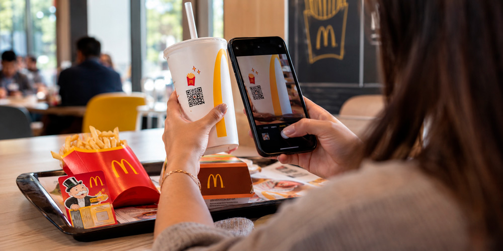 Cliente escaneando el QR de un vaso de McDonald’s durante la promoción Monopoly